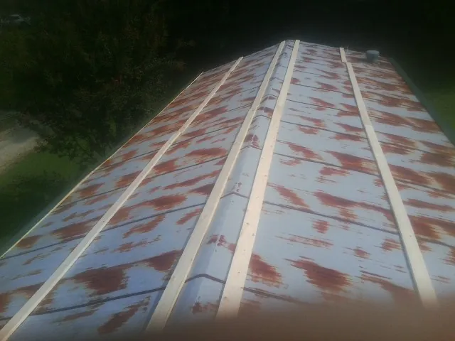 Rusted metal roof panels with new wood purlins before replacement — Storm Damage Roof Repair in Mc Bain by Roofing Brothers